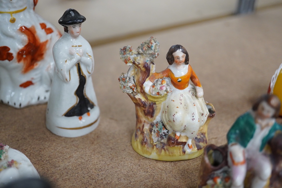 A collection of 19th century and later Staffordshire figures, mostly figural examples, including a pair a rare pair of porcelain seated figures with rabbits and a candle extinguisher, largest 15cm high (15)